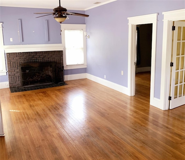 unfurnished living room featuring a brick fireplace, ceiling fan, and hardwood / wood-style flooring