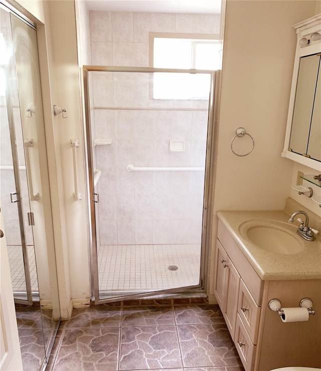 bathroom with a shower with door and vanity