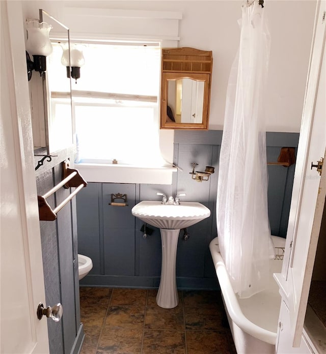 bathroom with toilet, decorative backsplash, and shower / bath combo with shower curtain