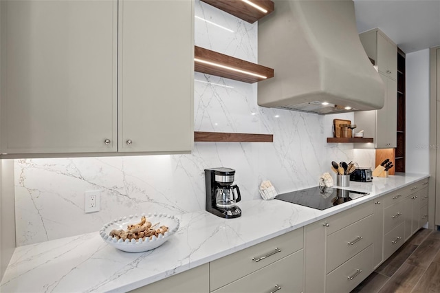 kitchen featuring decorative backsplash, ventilation hood, light stone counters, and black electric cooktop