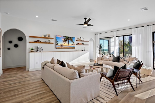 living room featuring light hardwood / wood-style flooring and ceiling fan