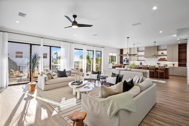 living room featuring ceiling fan and light hardwood / wood-style floors