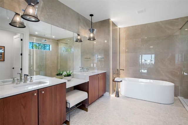 bathroom featuring vanity, a bath, and tile walls