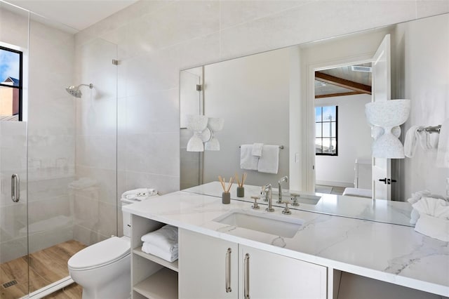 bathroom featuring hardwood / wood-style floors, vanity, toilet, and a shower with door