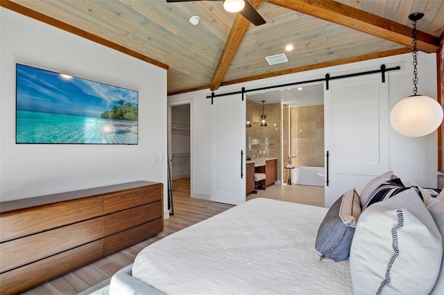 bedroom with ceiling fan, a barn door, ensuite bathroom, a closet, and light wood-type flooring