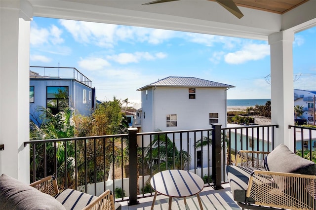 balcony with a water view and ceiling fan