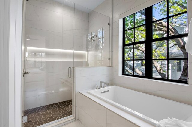 bathroom featuring shower with separate bathtub