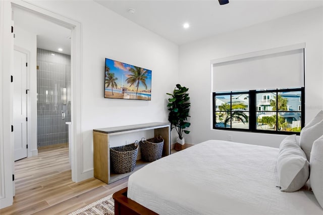 bedroom with light wood-type flooring, ensuite bath, and ceiling fan