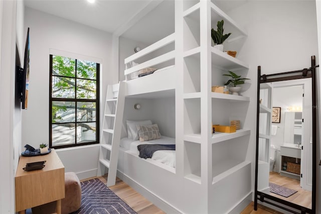 bedroom featuring ensuite bathroom and light wood-type flooring