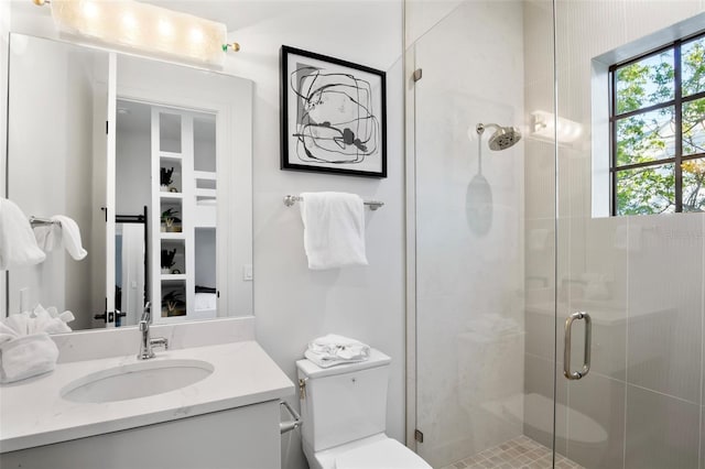 bathroom with vanity, toilet, and an enclosed shower