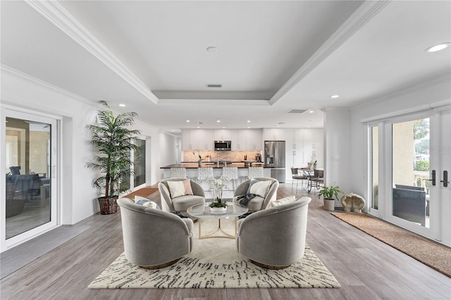 living room featuring crown molding and light hardwood / wood-style flooring