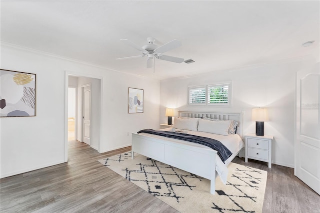 bedroom with ceiling fan, hardwood / wood-style floors, and ornamental molding