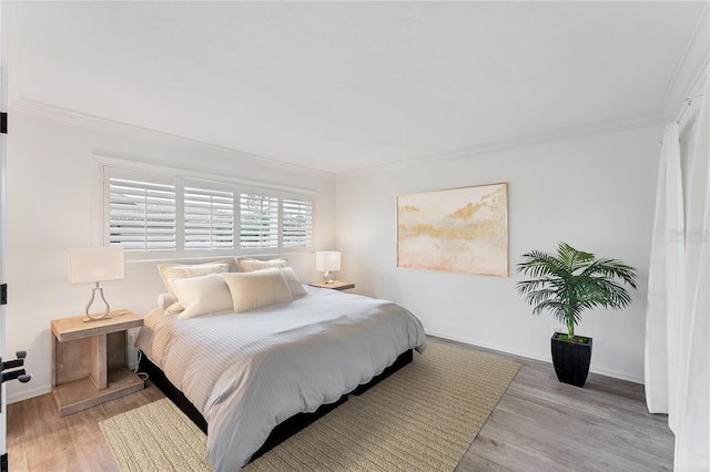 bedroom featuring light wood-type flooring and crown molding