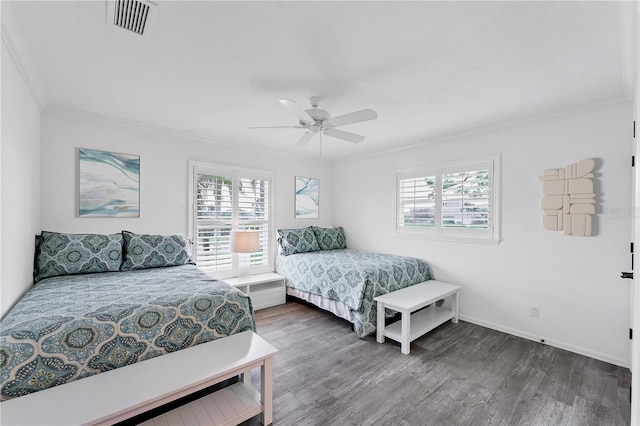 bedroom with dark hardwood / wood-style floors, ceiling fan, and ornamental molding