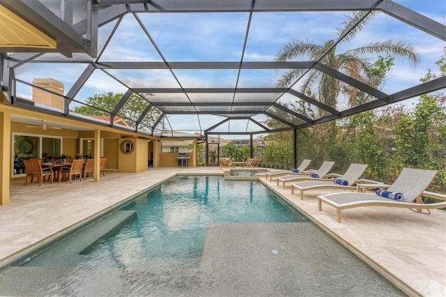 view of pool featuring glass enclosure, ceiling fan, an in ground hot tub, and a patio