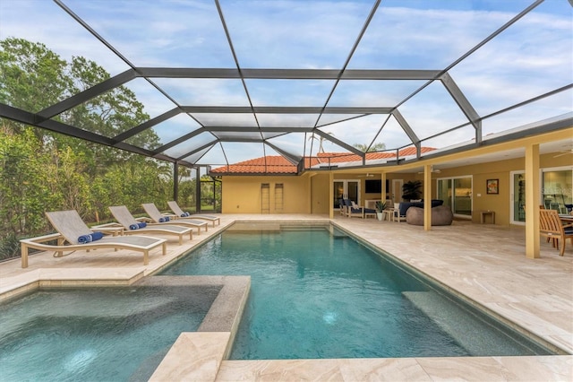 view of pool featuring glass enclosure, ceiling fan, and a patio area