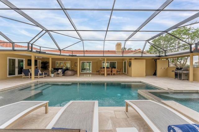 view of swimming pool with glass enclosure, ceiling fan, french doors, and a patio