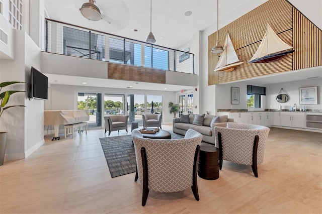 living room featuring ceiling fan, a towering ceiling, and light tile patterned flooring