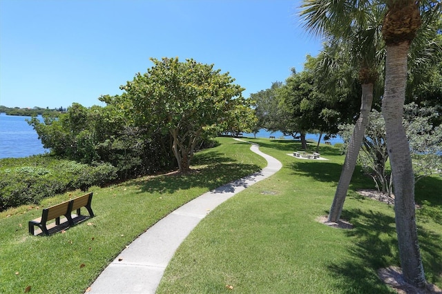 surrounding community with a lawn and a water view