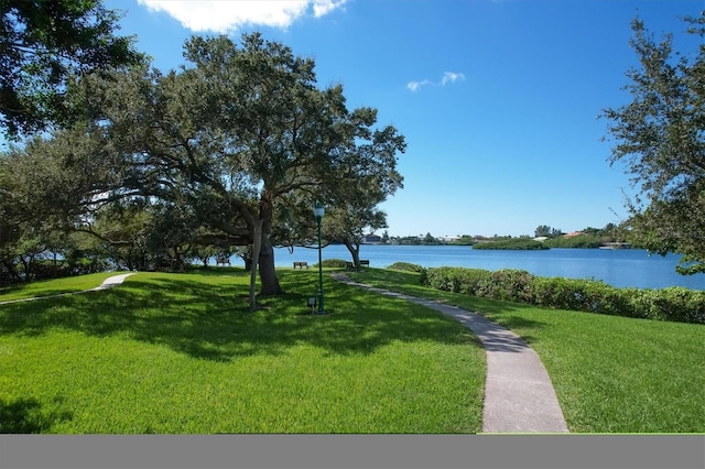 surrounding community featuring a lawn and a water view