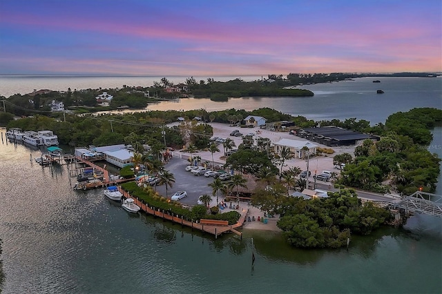 aerial view at dusk featuring a water view