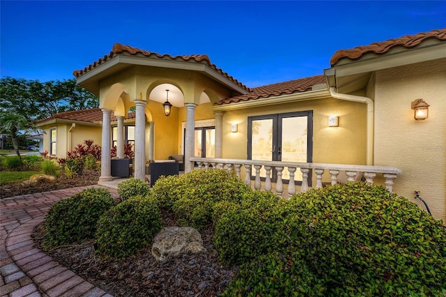 312 Yacht Harbor Dr, Osprey, FL 34229 - property entrance with a tiled roof, french doors, and stucco siding