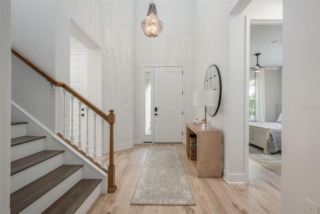 entryway with light wood-type flooring and a towering ceiling