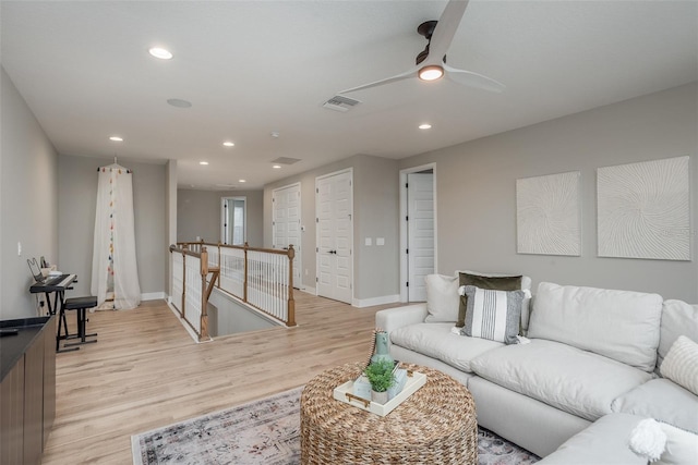 living room featuring ceiling fan and light hardwood / wood-style floors