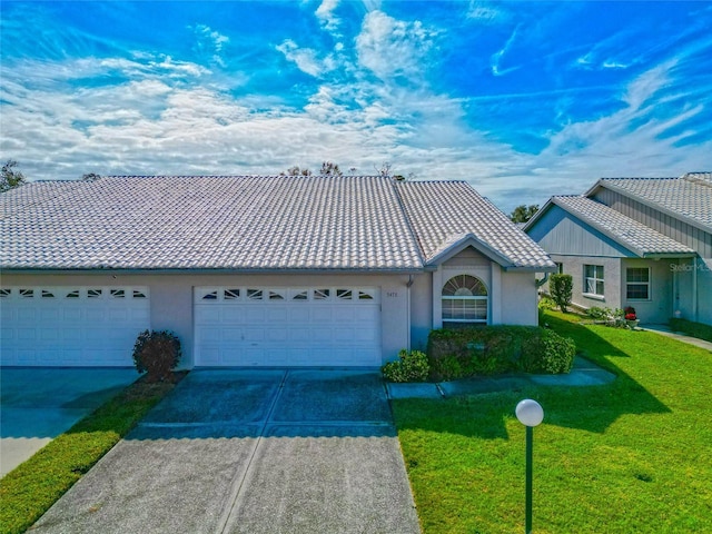 single story home featuring a garage and a front lawn