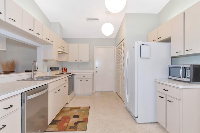 kitchen featuring pendant lighting, stainless steel appliances, white cabinetry, and sink