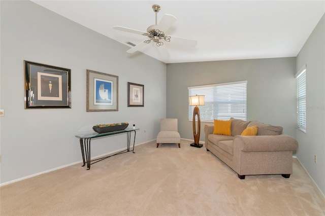 sitting room with ceiling fan, light colored carpet, and vaulted ceiling