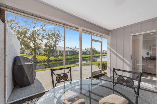 sunroom / solarium featuring a water view