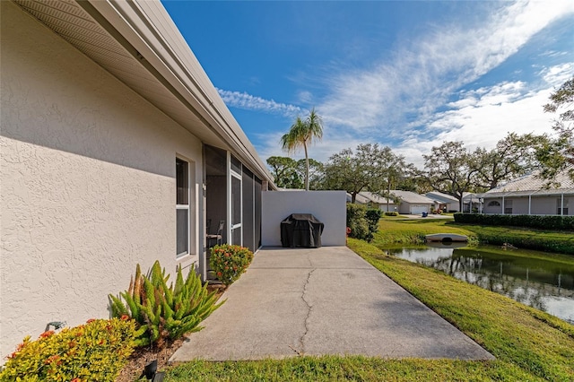 view of home's exterior featuring a lawn and a water view