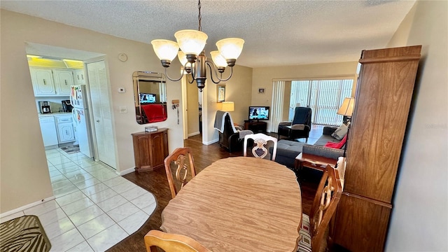 11485 Oakhurst Rd Unit 200-220, Largo, FL 33774 - dining area featuring a chandelier, a textured ceiling, tile patterned flooring, and baseboards