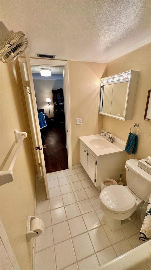 bathroom featuring vanity, a textured ceiling, hardwood / wood-style flooring, and toilet