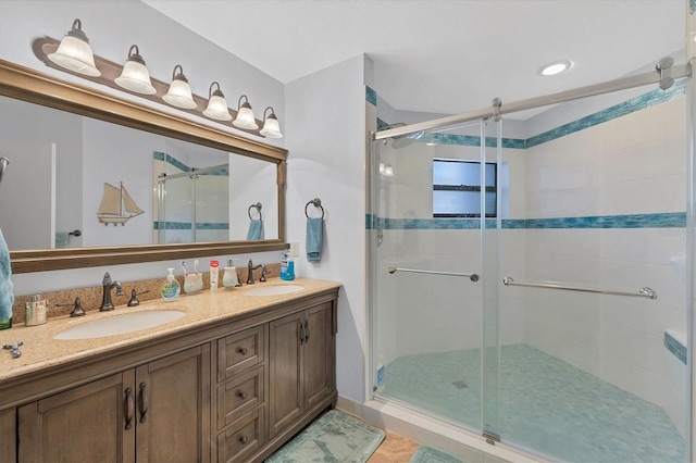 bathroom with a shower with door, vanity, and tile patterned flooring