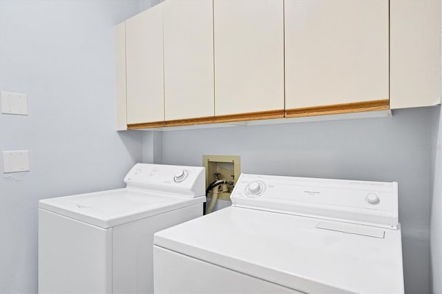 laundry room with washer and dryer and cabinets