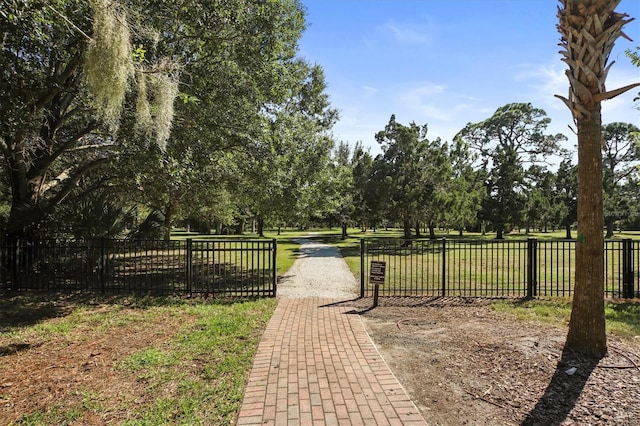 view of gate with a lawn