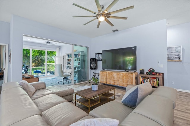 living room with ceiling fan, hardwood / wood-style flooring, and a textured ceiling