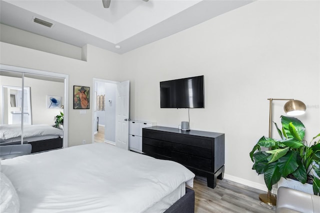 bedroom featuring light hardwood / wood-style floors, ceiling fan, and a closet