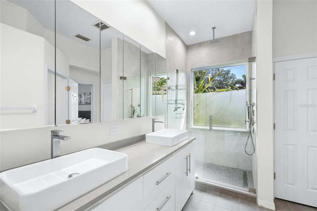 bathroom with tile patterned flooring, vanity, and a shower with shower door