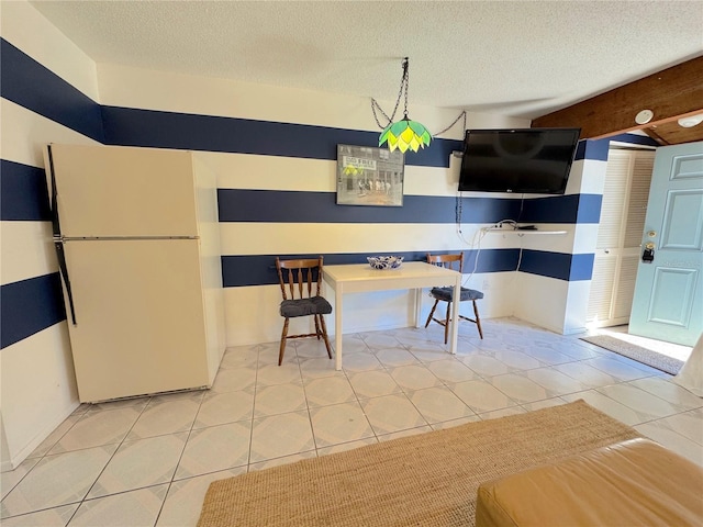 unfurnished dining area with light tile patterned floors and a textured ceiling