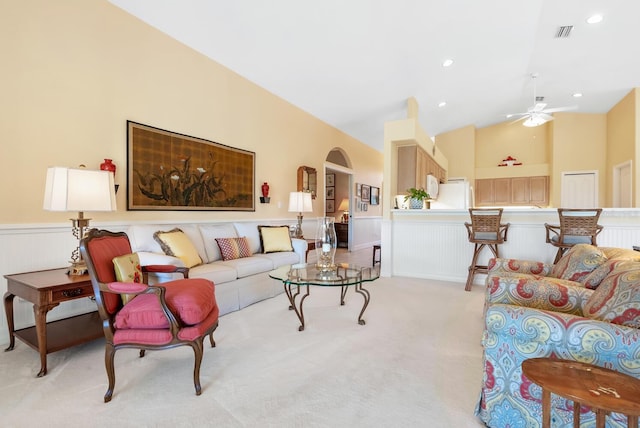 living room with ceiling fan, light colored carpet, and vaulted ceiling