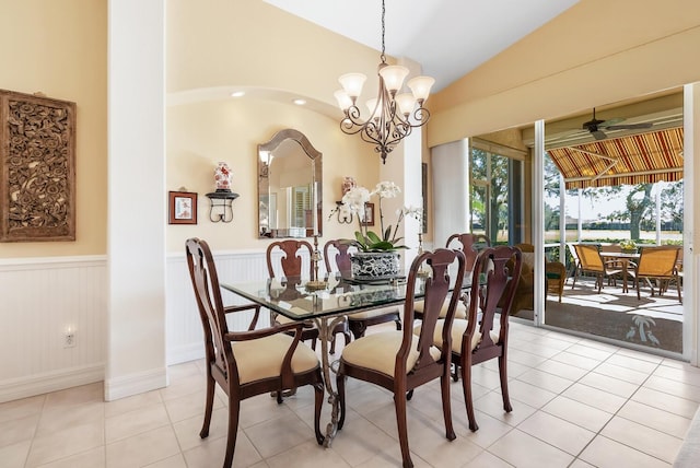 tiled dining room with lofted ceiling and ceiling fan with notable chandelier