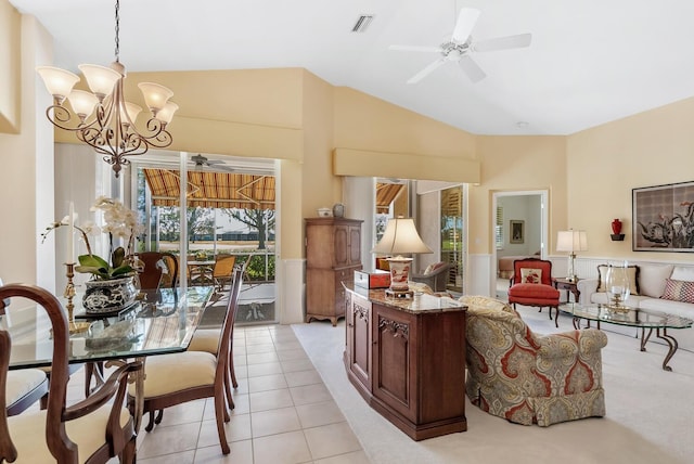 interior space featuring hanging light fixtures, stone countertops, lofted ceiling, light tile patterned flooring, and ceiling fan with notable chandelier