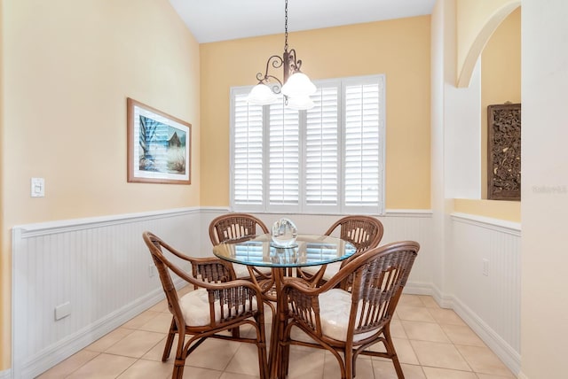 tiled dining room featuring a notable chandelier