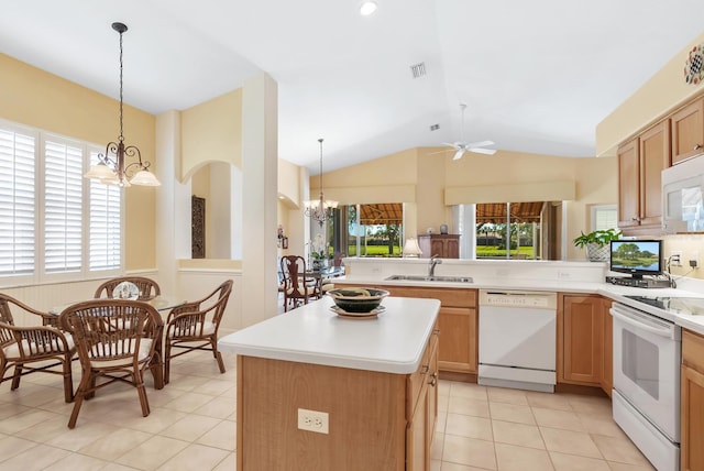 kitchen with white appliances, vaulted ceiling, sink, pendant lighting, and a kitchen island