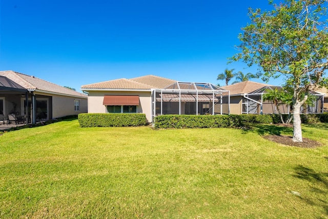 back of house with a lawn and a lanai