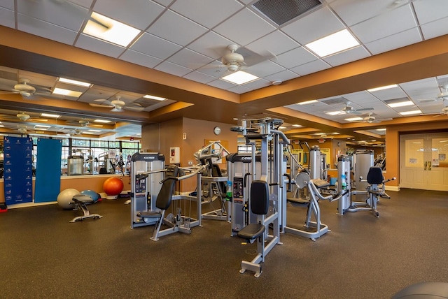 exercise room featuring a paneled ceiling and ceiling fan