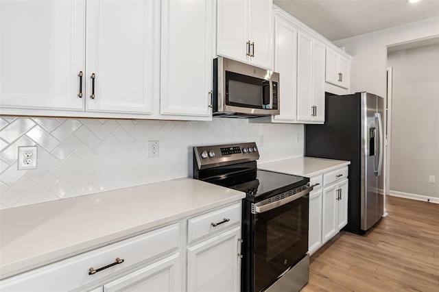 kitchen with decorative backsplash, white cabinetry, light hardwood / wood-style flooring, and appliances with stainless steel finishes